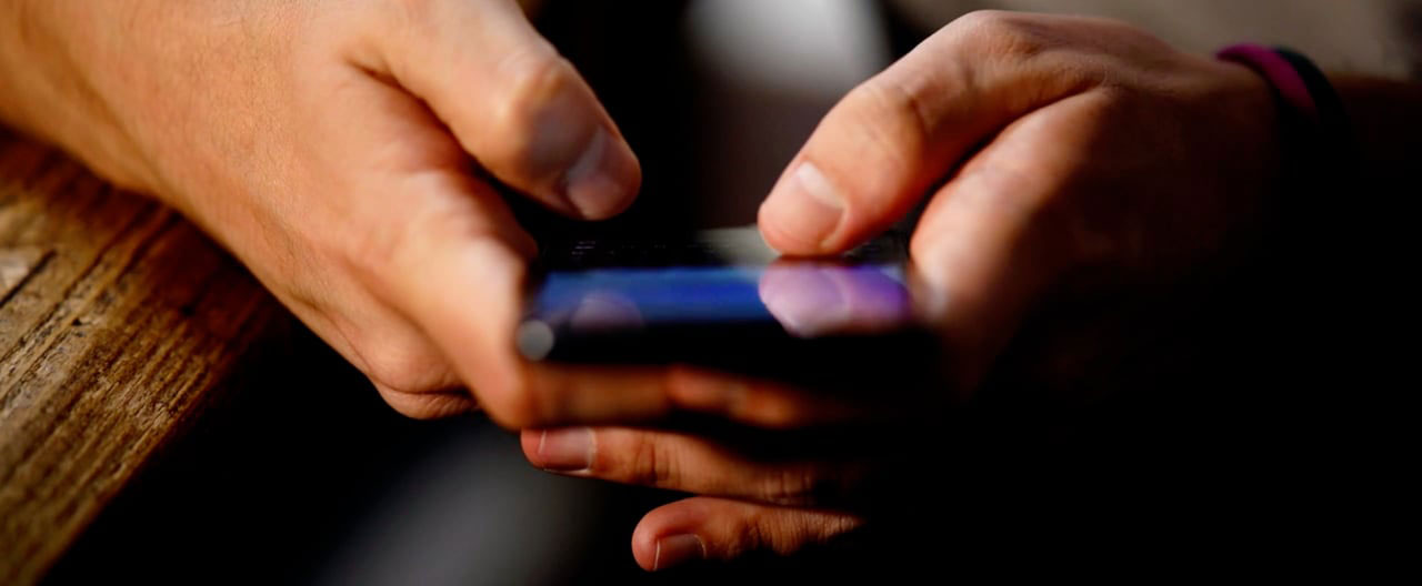 Professional scrolling phone video content on subway without earbuds demonstrating silent viewing
