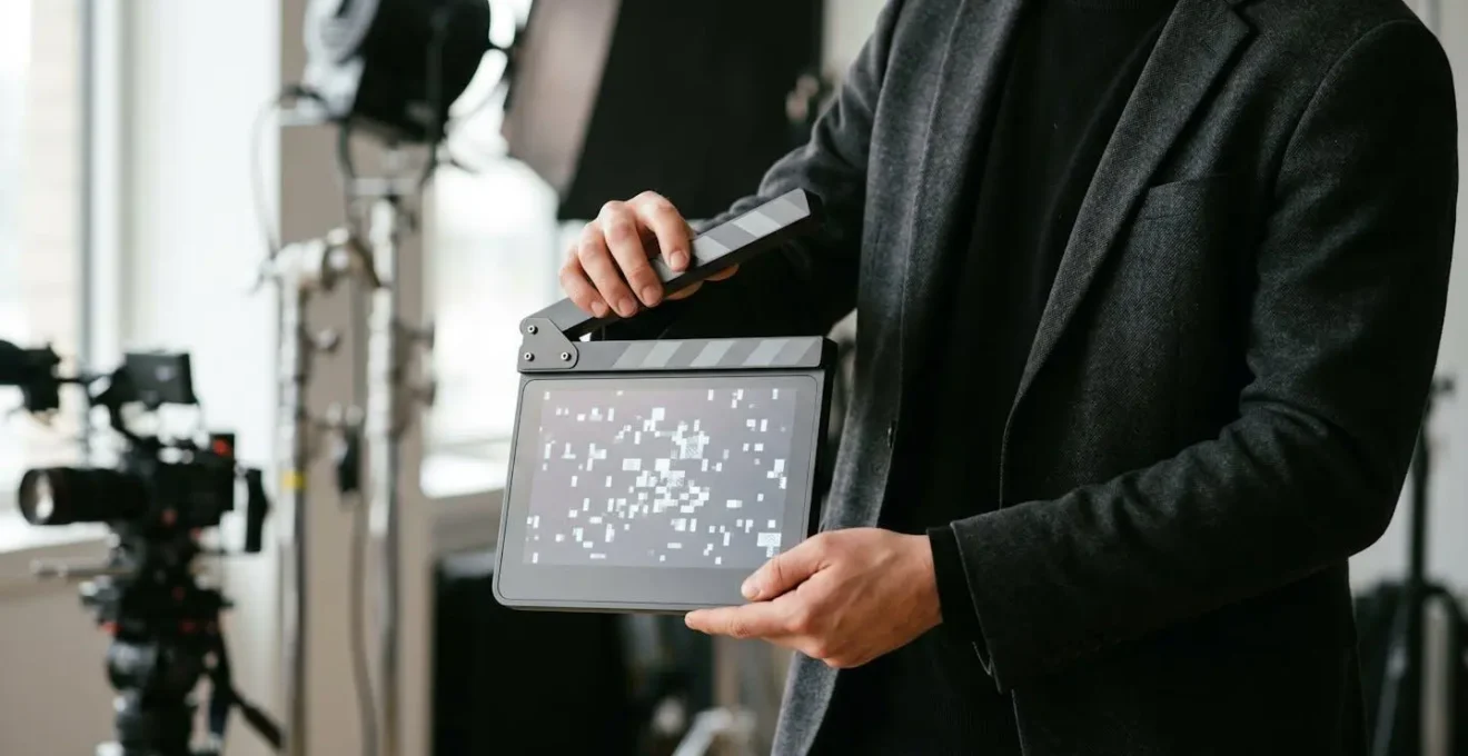 Professional filmmaker holding a digital slate in an interview setting with soft lighting